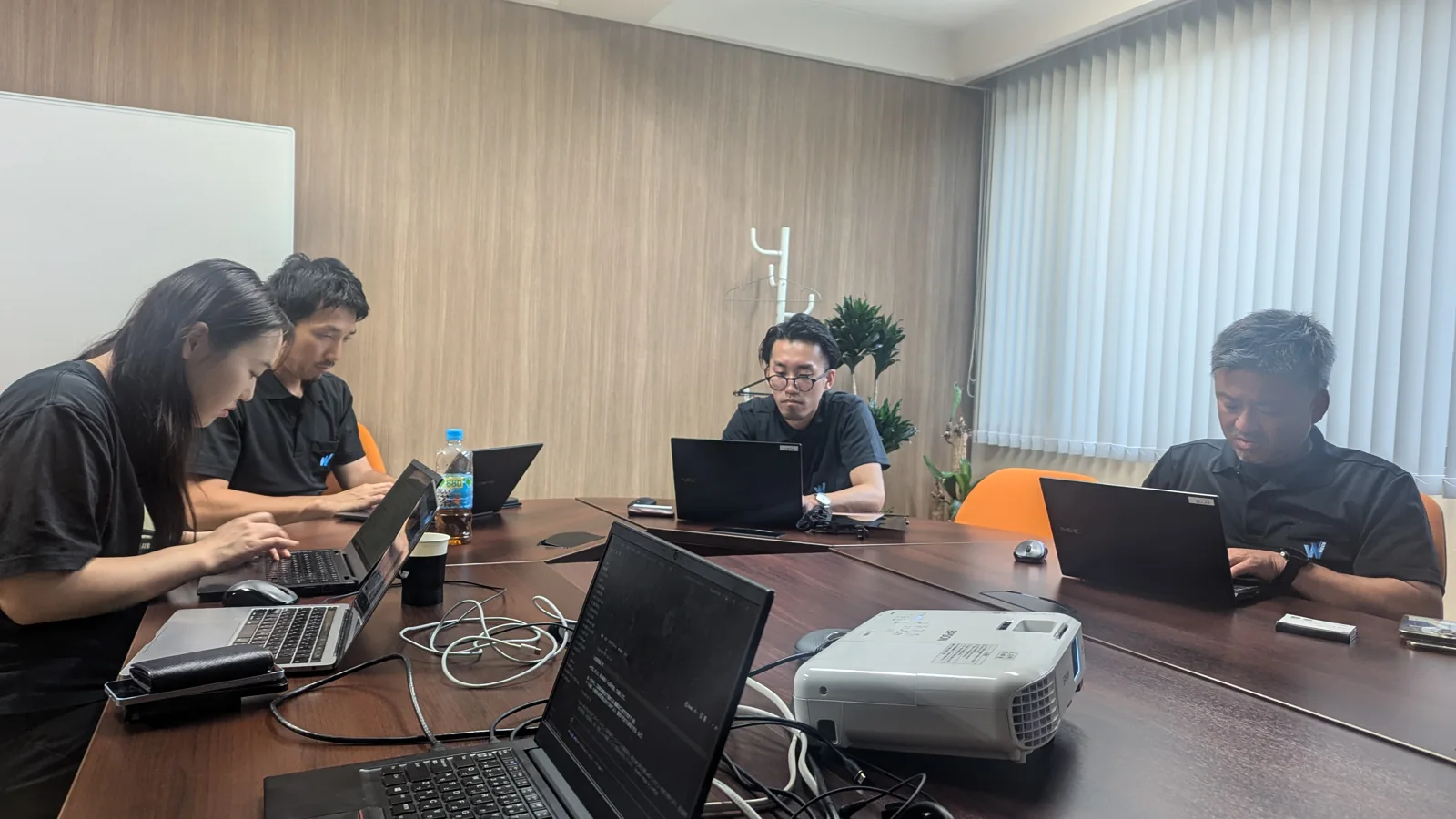 WECSの会議室で、社員の方々がそれぞれのノートPCに向かって作業している様子