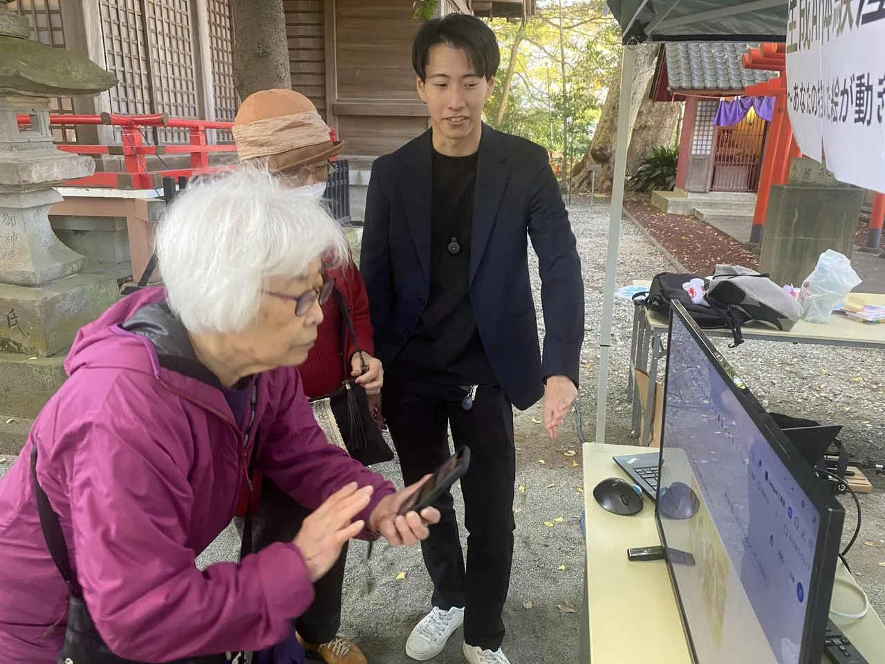 地域のイベントで参加者に説明する赤堀