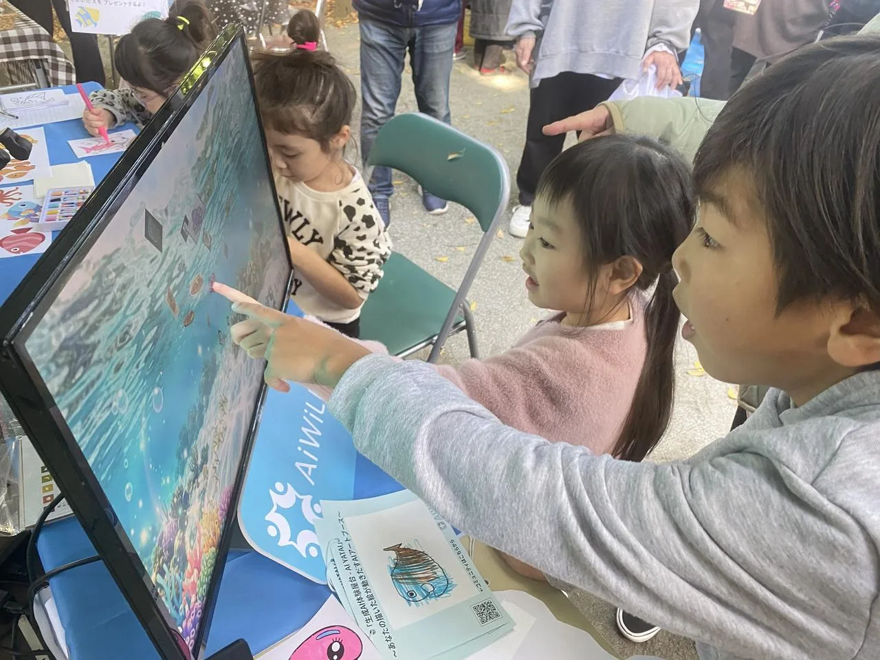 画面に触れてAIの作品づくりを楽しむ子どもたち