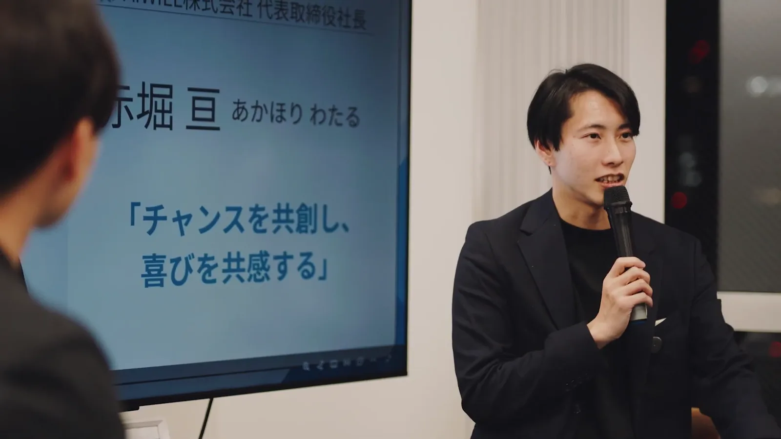 スライドの前で話す登壇者