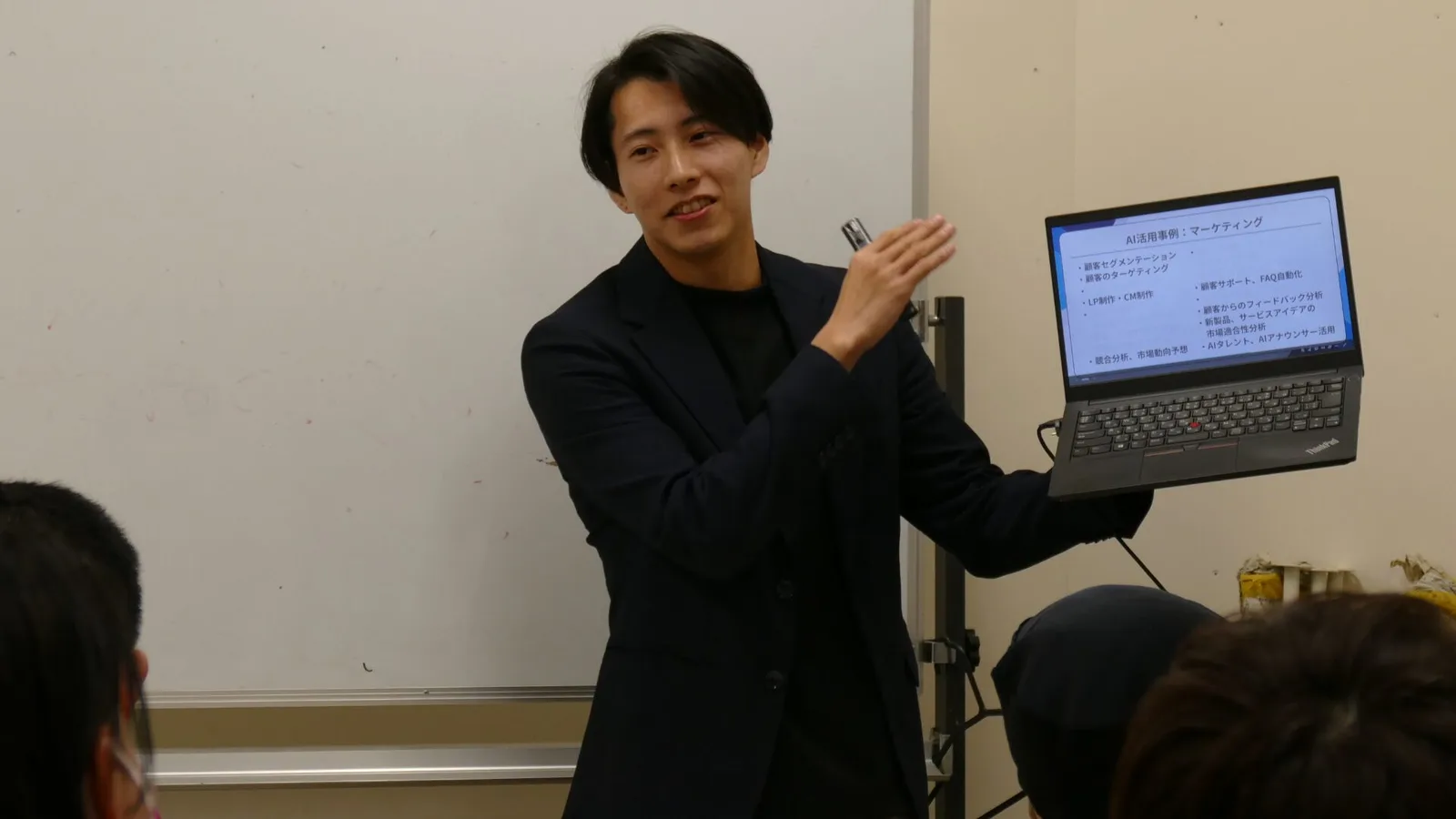 ノートパソコンを手に、AIの使い方を実演する講師